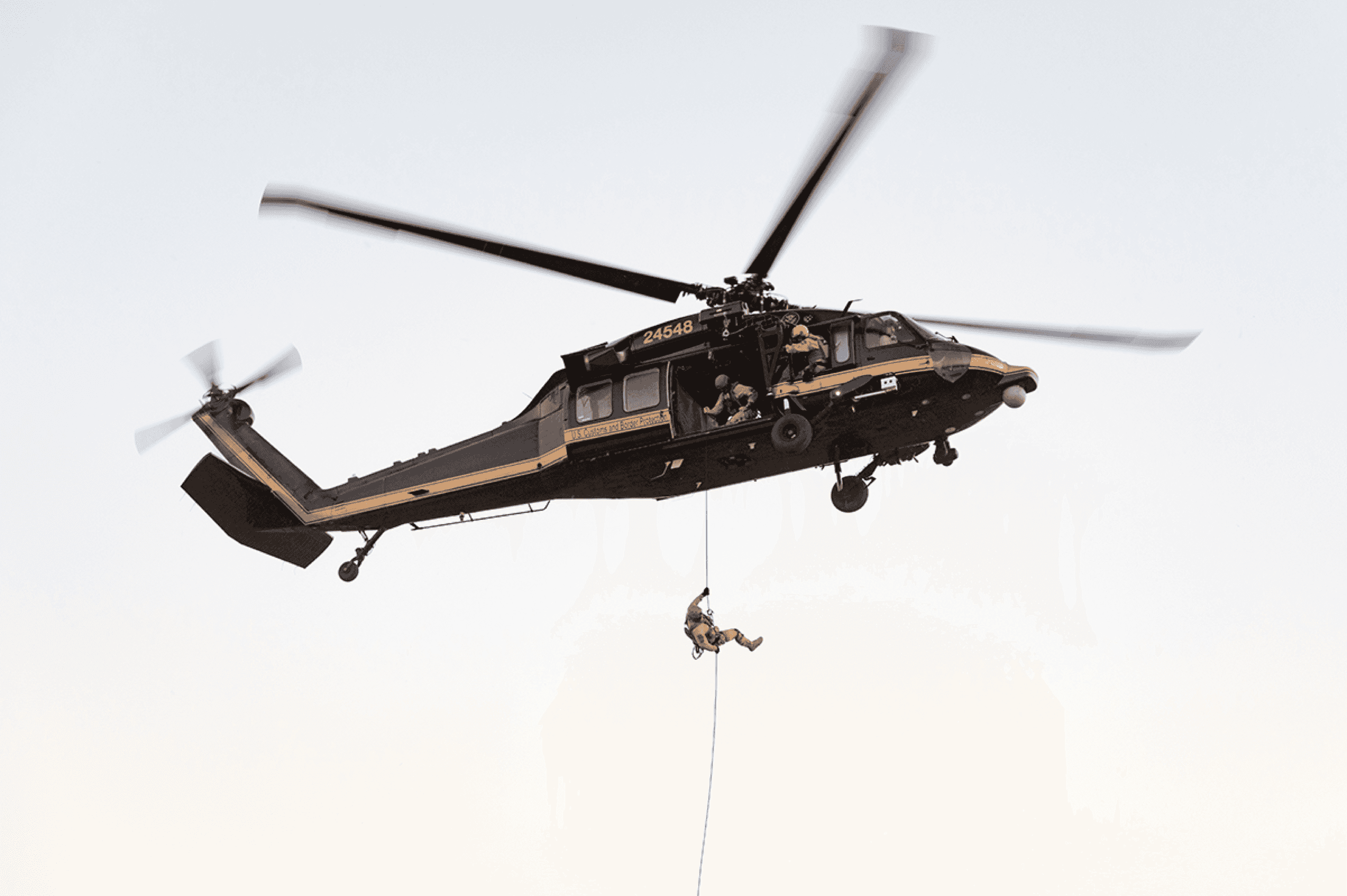 Politibetjent, der ryger ud af helikopteren under operation med efterretningssoftware
